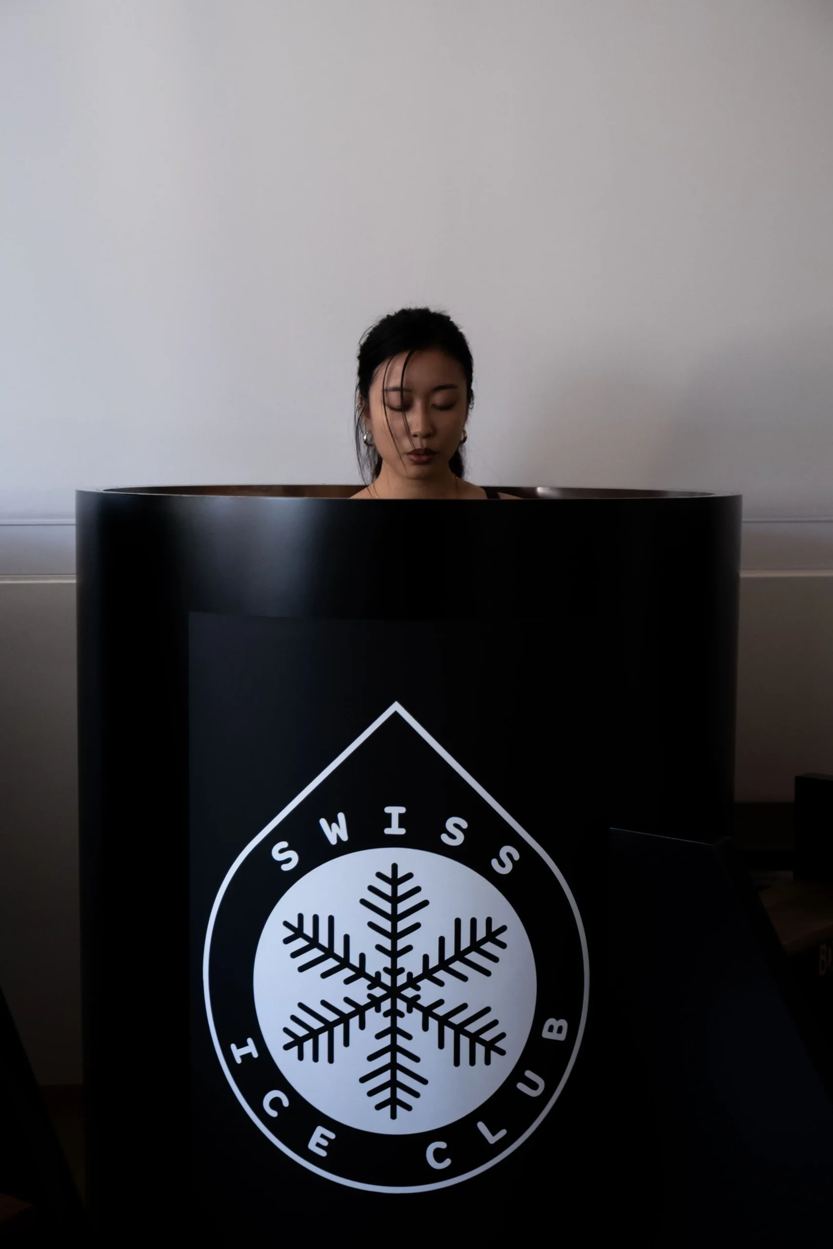 Femme en immersion dans un bain froid noir Swiss Ice Club à Carouge, Genève